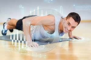 Smiling man doing push-ups in the gym