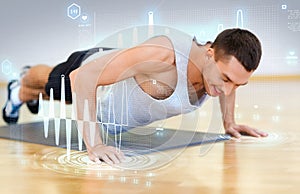 Smiling man doing push-ups in the gym