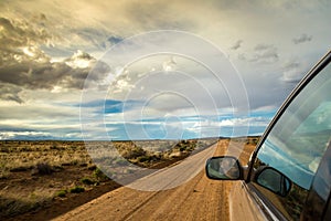 Smiling man driving through wilderness on dirt road