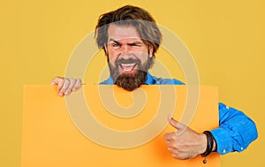 Smiling man with empty advertising banner for your text. Bearded guy shows thumb up. Big sale and discount. Black friday