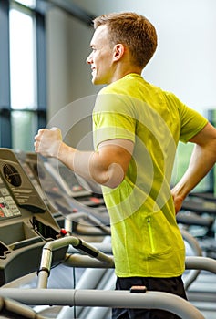 Smiling man exercising on treadmill in gym