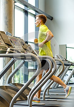 Smiling man exercising on treadmill in gym