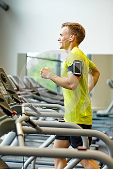 Smiling man exercising on treadmill in gym