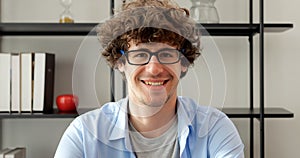 Smiling man with eyeglasses using laptop working at home