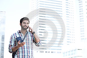 Smiling man gesturing while using cell phone in city