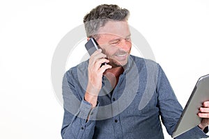 Smiling man happy handsome businessman using tablet computer while talking by phone