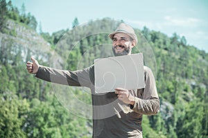 Smiling man in a hat and with a beard stops the car