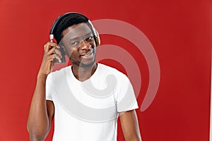 smiling man with headphones listening to music entertainment red background