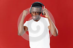 smiling man in headphones listening to music in white t-shirt isolated background
