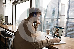 Smiling man in headphones study distant with coach on computer