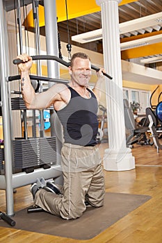 Smiling man in his forties exercising in gym