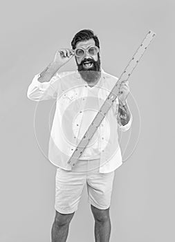 smiling man hold measuring ruler in studio. man hold measuring ruler on background.