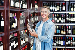 Smiling man holding bottle of wine