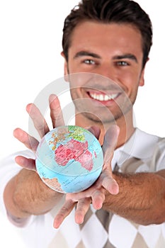 Smiling man holding globe