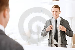 Smiling man holding jacket put on him