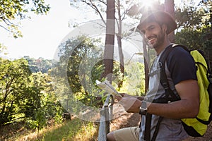 Smiling man holding the map and standing near the fence