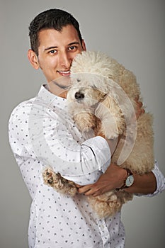 Smiling man holding poodle dog