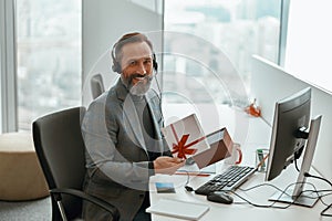 Smiling man holding present box and opening it