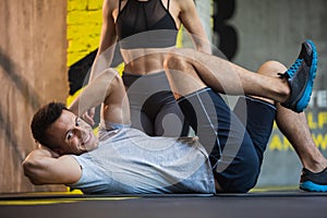 Smiling man id doing side crunches in gym