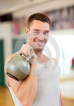 Smiling man with kettlebell in gym