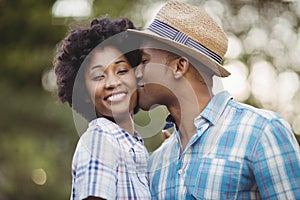 Smiling man kissing her girlfriends cheek