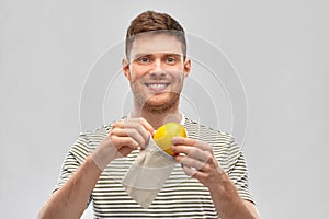 Smiling man with lemon in reusable canvas bag