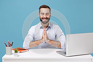Smiling man in light shirt sit work at desk with pc laptop isolated on blue background. Achievement business career