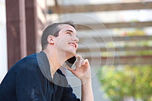 Smiling man listening to mobile phone conversation