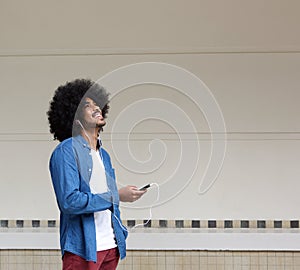 Smiling man listening to music from mobile phone