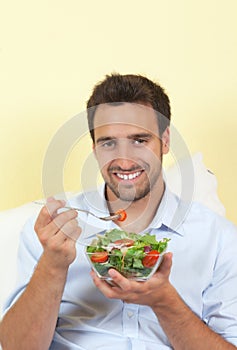 Smiling man loves salad