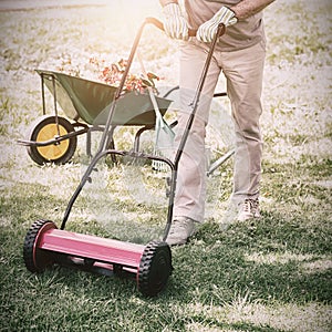 Smiling man mowing lawn