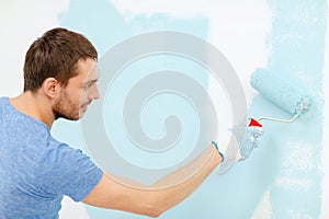 Smiling man painting wall at home