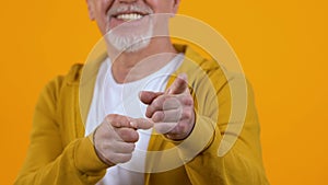Smiling man pointing fingers on camera, hey you gesture, informal communication