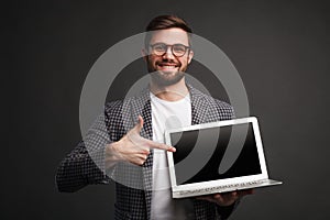 Smiling man pointing at laptop