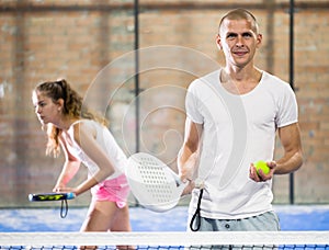 Smiling man ready for doubles paddle tennis match