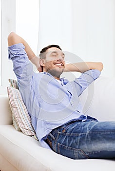 Smiling man relaxing on couch at home