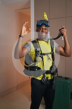 Smiling man in scuba suit showing ring gesture