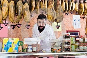 Smiling man seller showing sorts of meat