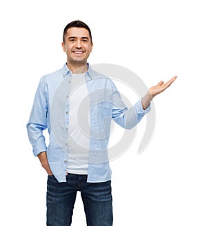 Smiling man showing something on empty palm