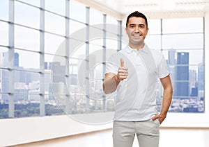 Smiling man showing thumbs up over office or home