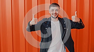 Smiling man shows a gesture or sign of like and dislike, thumb up and thumb down