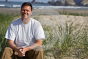 Smiling Man sitting on Beach