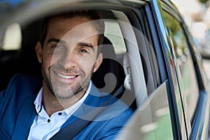 Smiling man sitting in his car during his morning commute