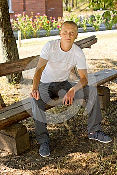 Smiling man sitting on a park bench
