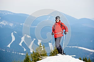 Smiling man skier standing on the top of the hill at ski resort Bukovel