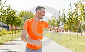 Smiling man with smart watch running outdoors