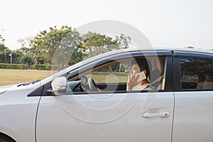 Smiling Man Speak on Smart Phone in White Car. The businessman successful driving his car and speaking on the cellphone