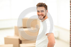 Smiling man standing in a new apartment