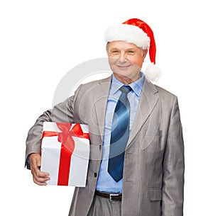 Smiling man in suit and santa helper hat with gift