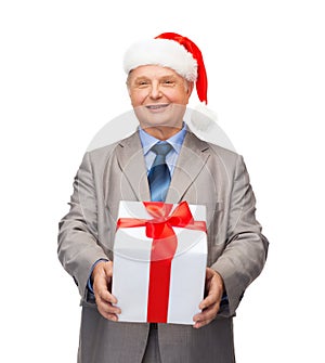 Smiling man in suit and santa helper hat with gift